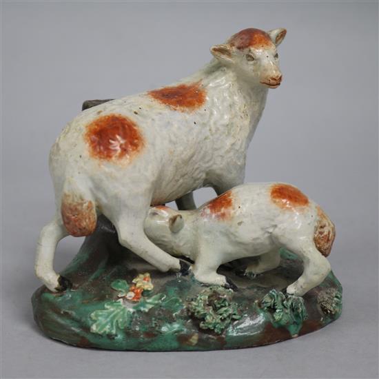 An early 19th century Staffordshire pottery group, ewe and suckling lamb, on grassy base